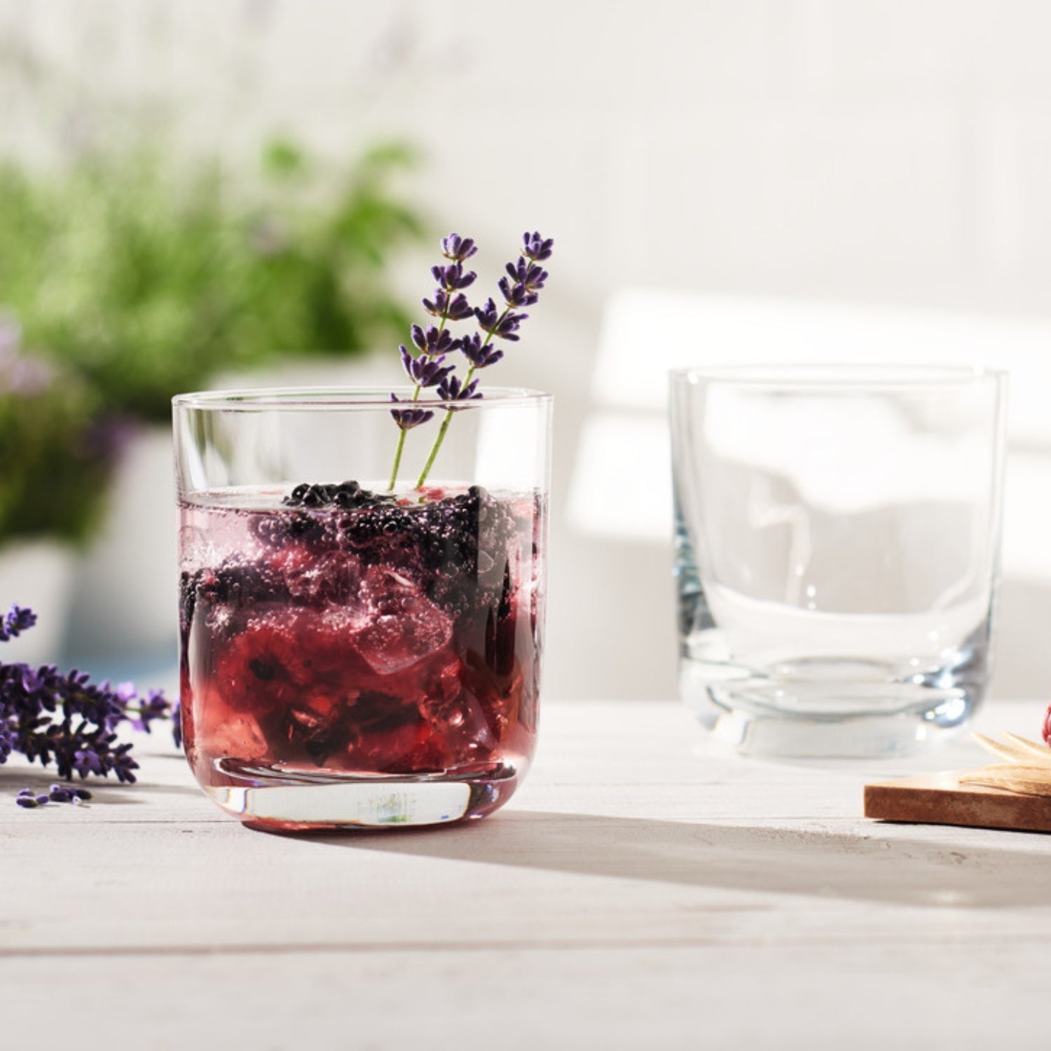 Tumbler mit Brombeeren, Eiswürfeln und Lavendel-Deko