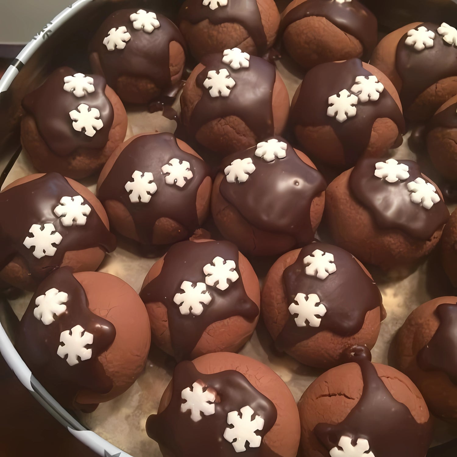 Schokokekse mit Zuckerguss-Schneeflocken dekoriert – hübsch angerichtet in einer Blechdose.