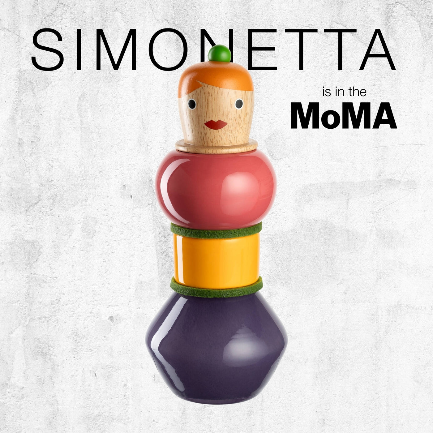 Stapelbare Figur mit hellbraunem Kopf, oranger Haarform, rotem Oberteil und violetter Basis. Text: „SIMONETTA is in the MoMA“.