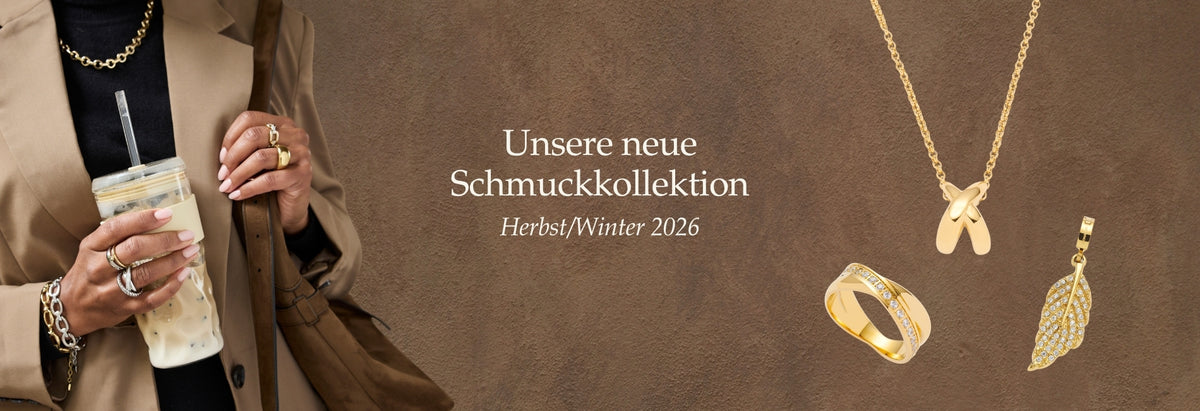 Unsere neue Schmuckkollektion Herbst/Winter 2026. Frau trägt goldene Ringe, Halsketten und Armbänder vor warmem, braunem Hintergrund
