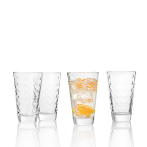 Vier Trinkgläser OPTIC, eines mit Orangensaft und Eiswürfeln gefüllt, drei leer