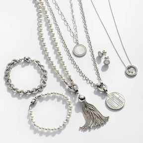 Silberschmuck-Kollektion mit Armbändern, Ketten und Ohrringen auf weißem Hintergrund