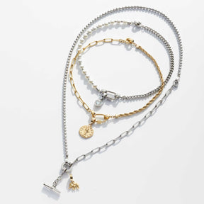 Mehrere silberfarbene und goldfarbene Armbänder mit verschiedenen Kettenglieder-Designs und austauschbaren Anhängern