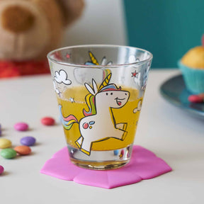 Kinderbecher BAMBINI mit Einhorn-Motiv auf rosa Untersetzer, umgeben von bunten Perlen
