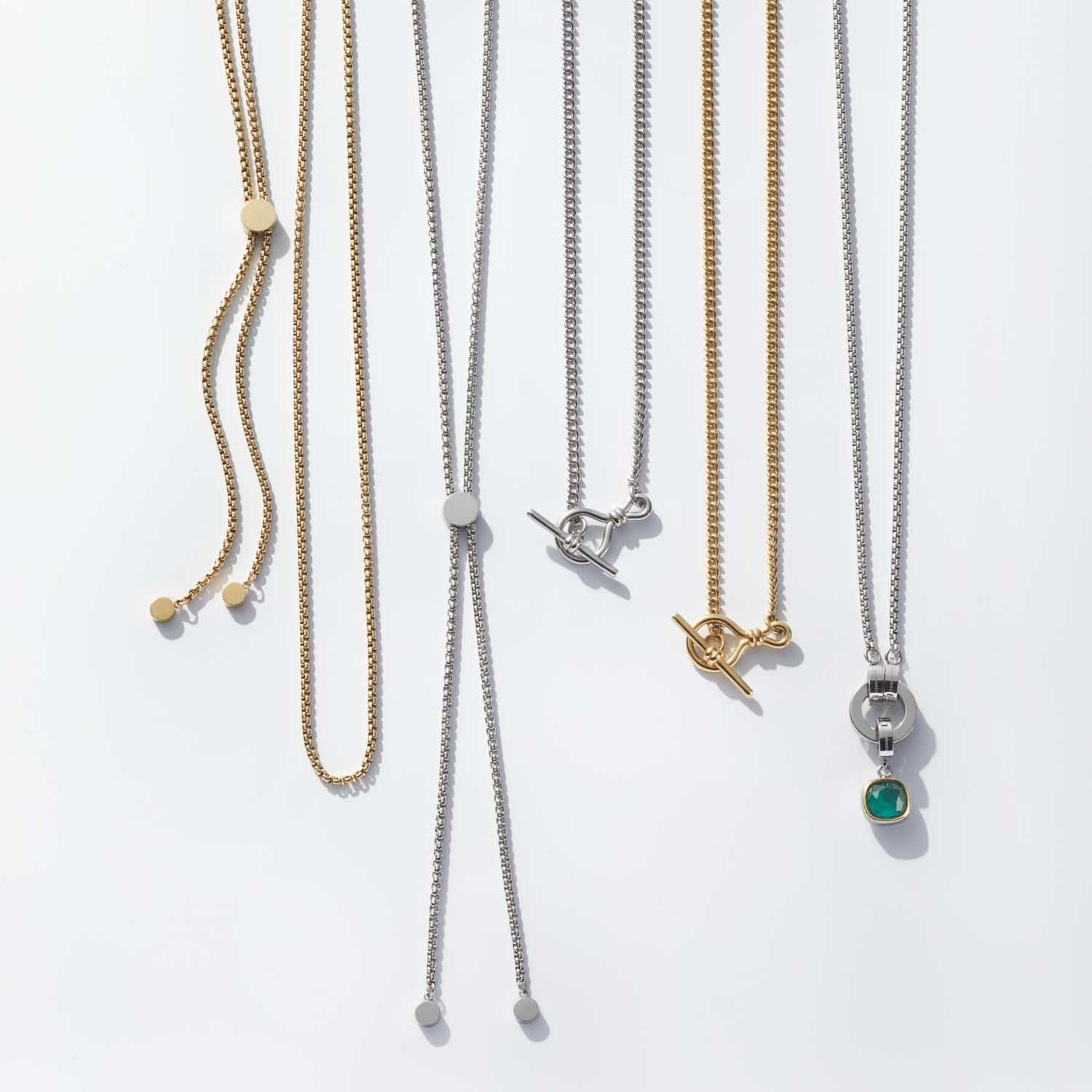 Mehrere Halsketten LOLITA in Silber und Gold mit verschiedenen Anhängern nebeneinander