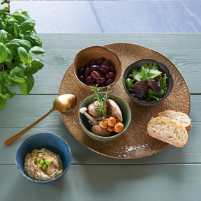 Keramikschalen in anthrazit mit Antipasti und Brot auf Holztablett