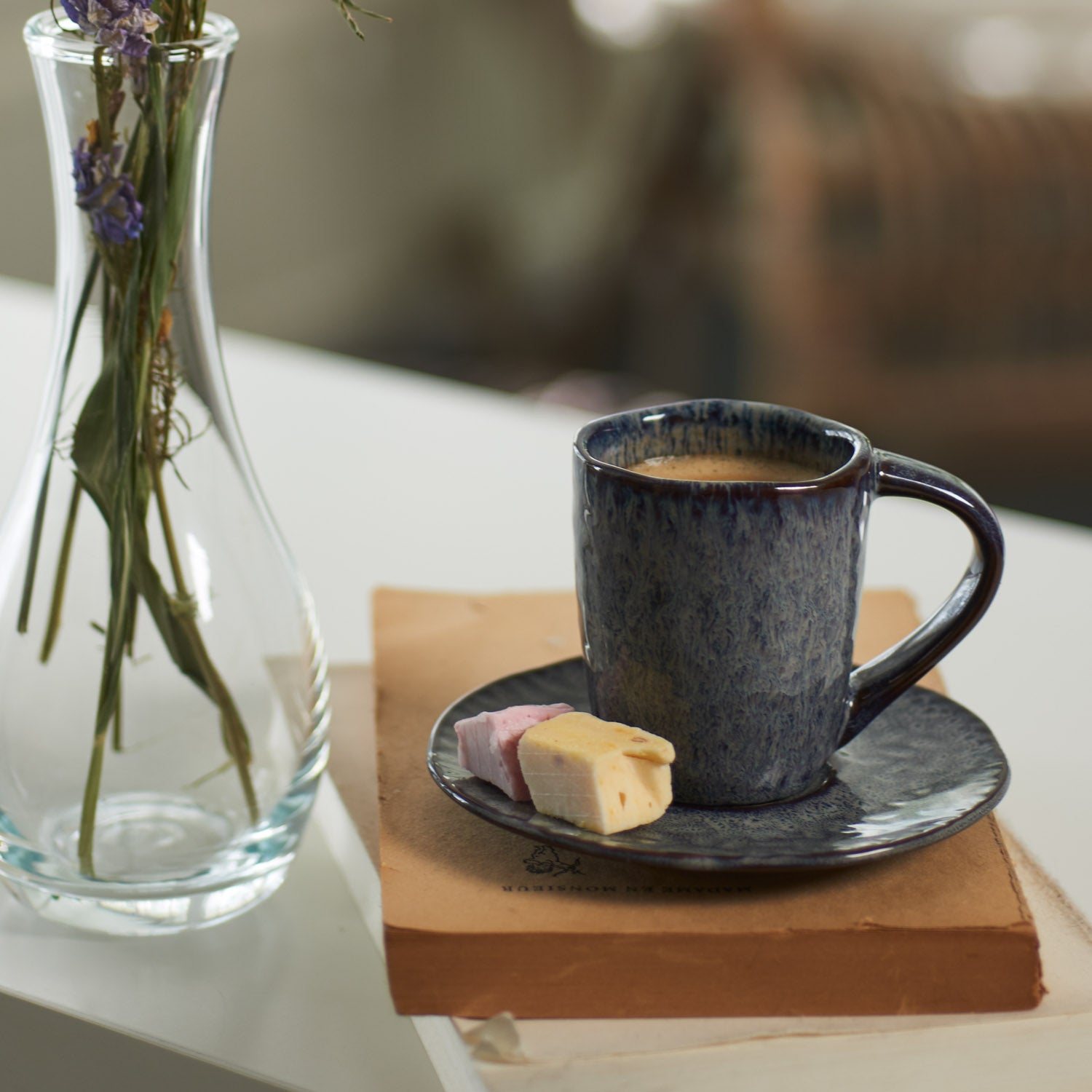 Keramikuntertasse MATERA anthrazit mit Kaffeetasse, Gebäck und Blumenvase auf Tisch