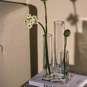 Solifleurvase NOVARA mit weißen Blüten und grünen Stielen auf Zeitschrift, Wohnraum