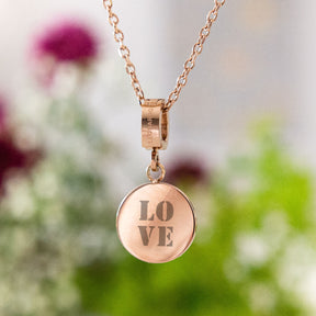 Anhänger MARI roségold mit Gravur LOVE an Kette, Blüten im Hintergrund