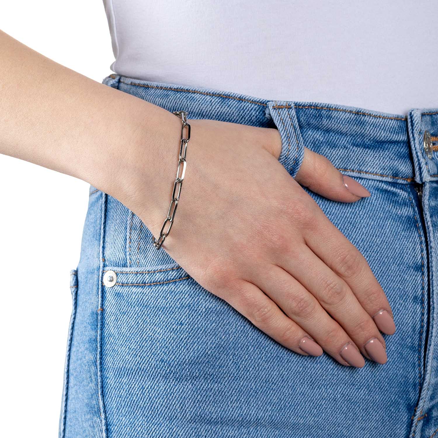 Frau traegt silbernes Kettenarmband ESTRELLA Clip & Mix an Handgelenk, blaue Jeans