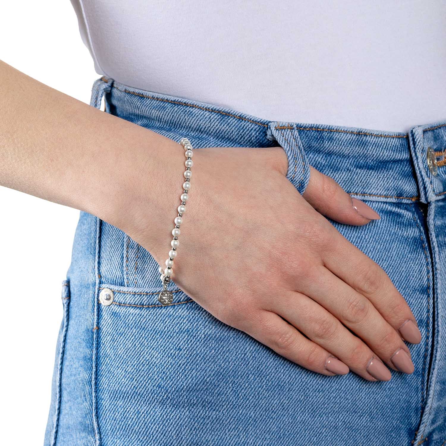 Armband PELENA CIAO weiß an Frauenhand getragen, Jeans im Hintergrund