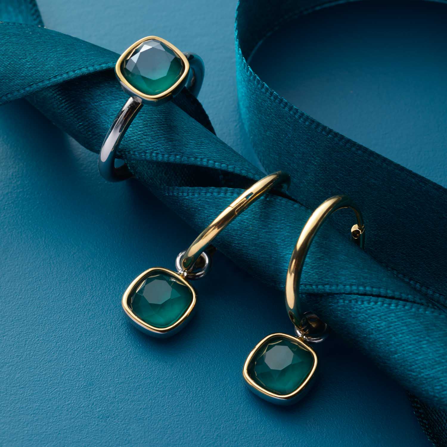 Creole ALIDA gold Beauty's mit grünen Steinen auf blauem Stoff