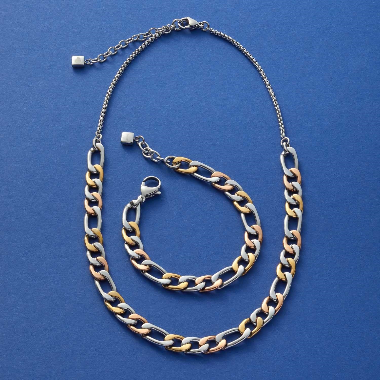 Halskette TRICOLORE und Armband aus tricolorem Edelstahl auf blauem Untergrund