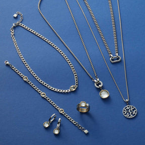 Silberner Schmuck der Serie BEAUTY'S auf blauem Hintergrund, Ketten, Ohrringe und Ring