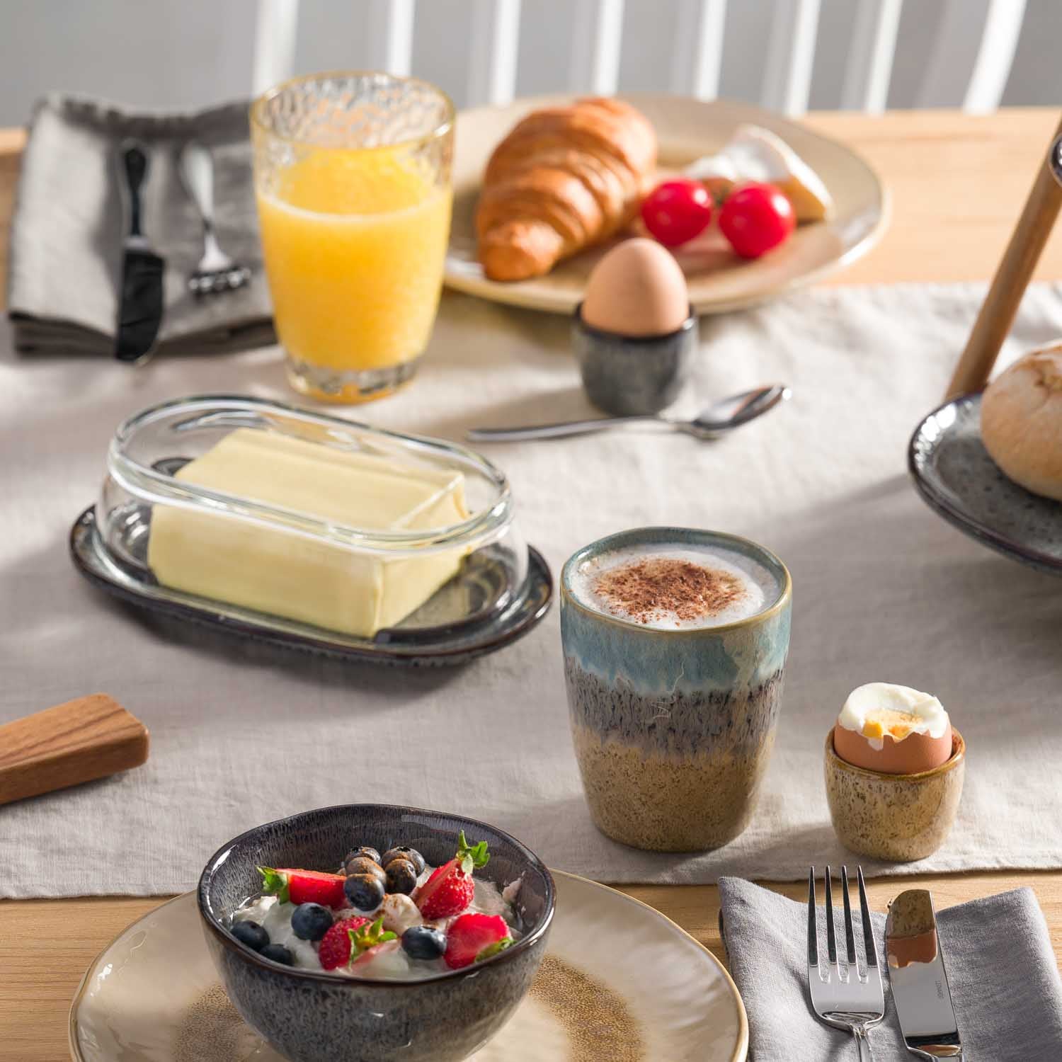 Keramikbecher MATERA in gedecktem Frühstückstisch mit Müsli, Croissant und Orangensaft