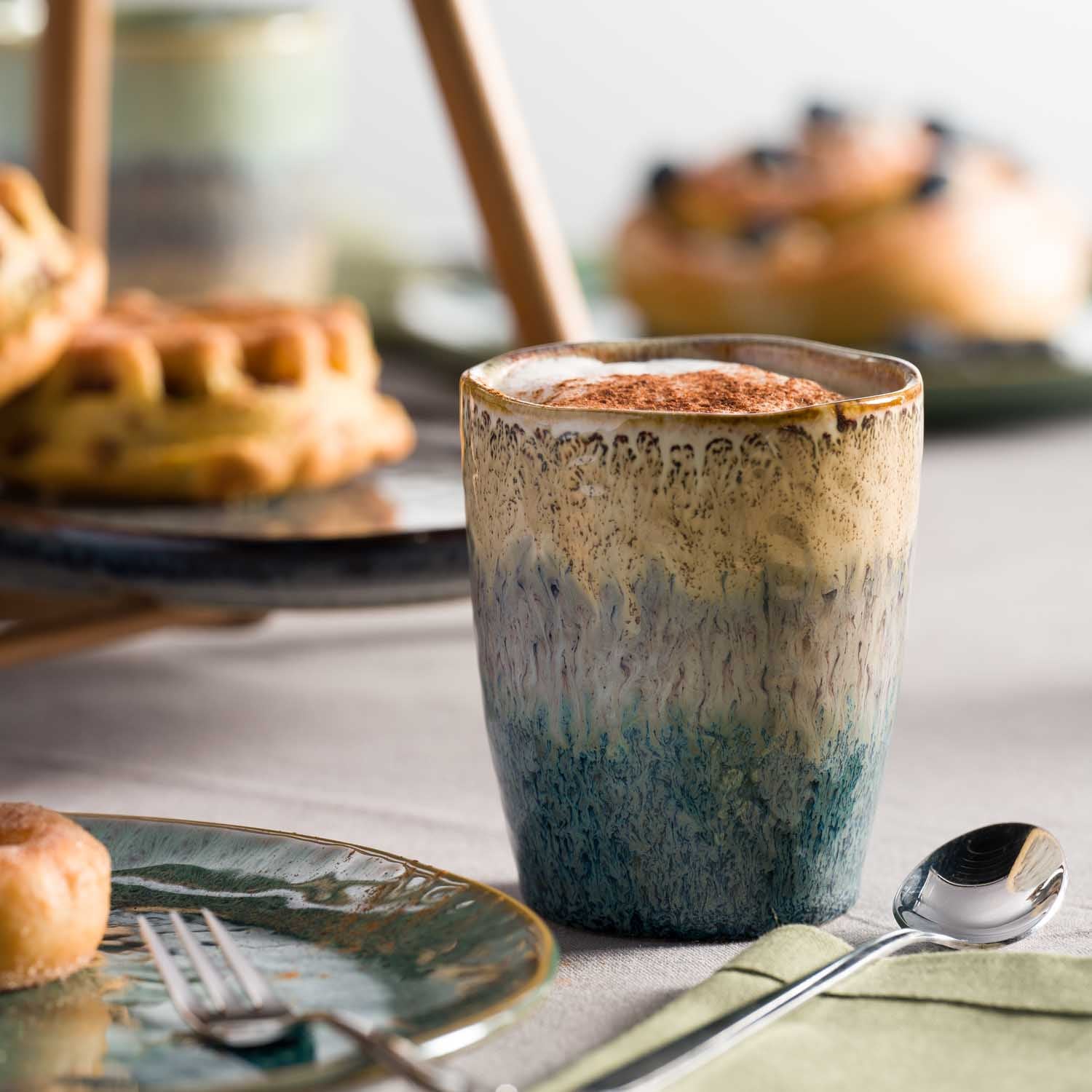 Keramikbecher MATERA auf gedecktem Tisch mit Gebäck und Besteck