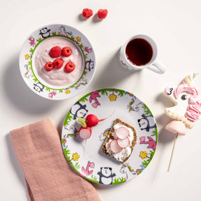 Kindergeschirr BAMBINI mit Panda- und Flamingo-Motiven, gedeckter Tisch mit Joghurt, Toast, Getränk und Süßigkeiten