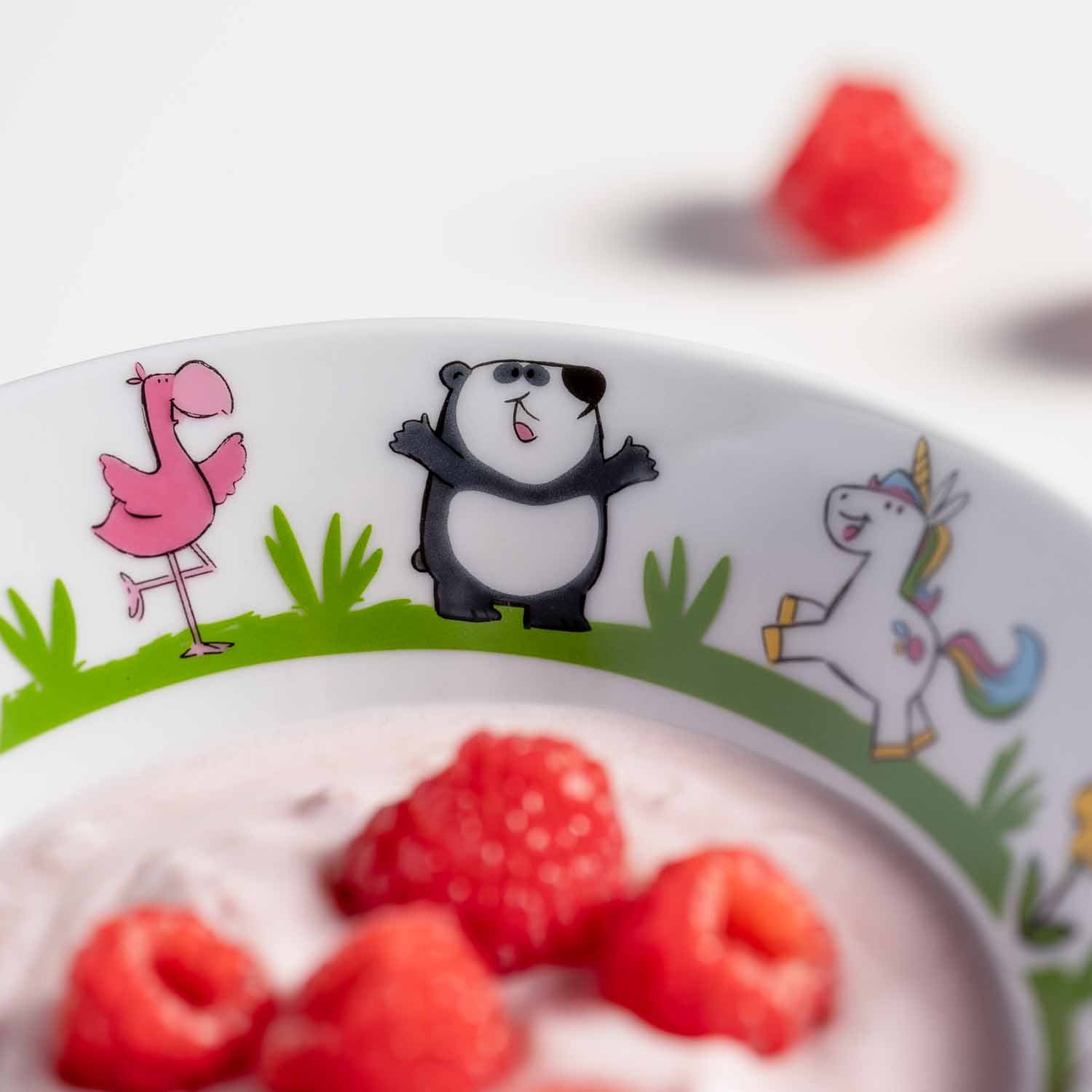 Kindergeschirr BAMBINI mit Flamingo, Panda und Einhorn, gefüllt mit roten Himbeeren