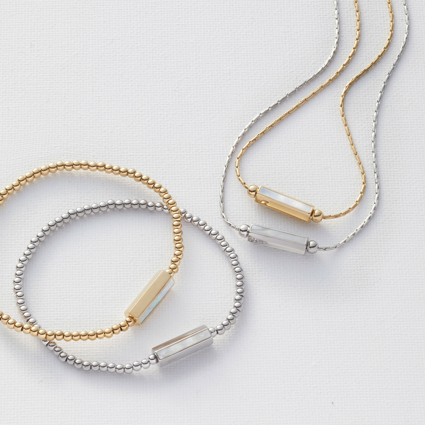 Armbänder PILEA in Gold und Silber mit Perlmutt-Elementen, Halskette mit graviertem Anhänger