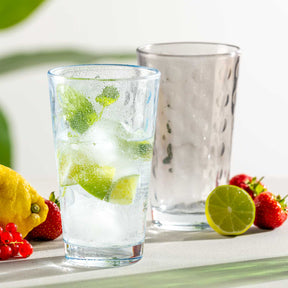 Trinkglas OPTIC mit Limette, Minze und Eis auf Tisch mit Früchten