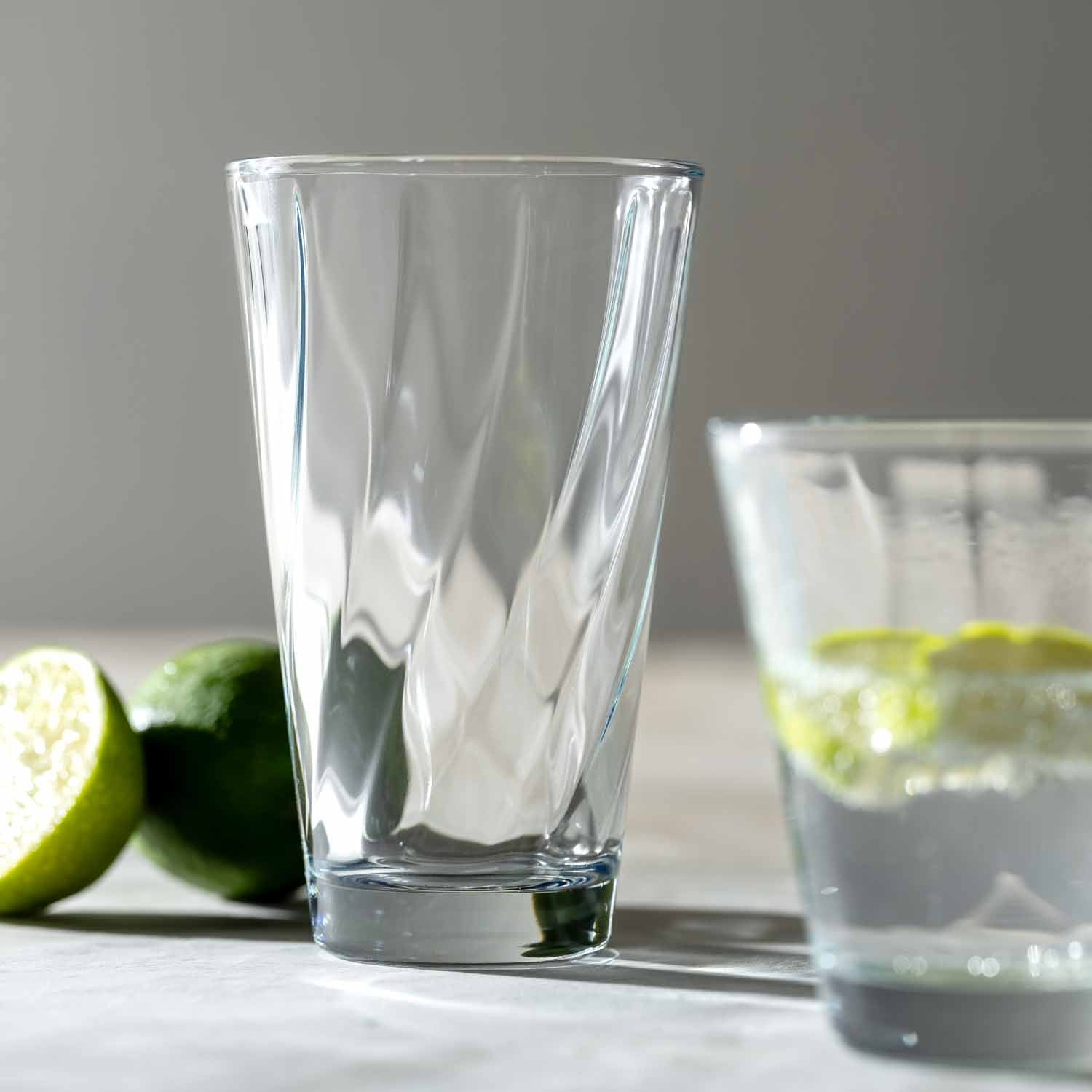 Trinkglasset TWIST mit klarem Glas, Limettenscheiben und gefülltem Glas auf weißer Oberfläche