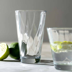 Trinkglasset TWIST mit klarem Glas, Limettenscheiben und gefülltem Glas auf weißer Oberfläche