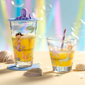 Trinkset BAMBINI AVVENTURA mit Bechern auf Sand, Muscheln und Seifenblasen im Hintergrund