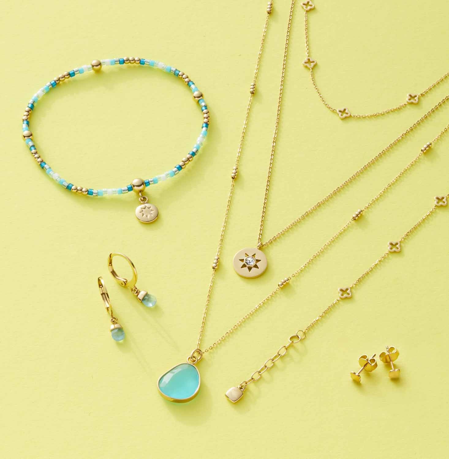 Halskette JANNA mit goldenem Schmuckset auf gelbem Hintergrund
