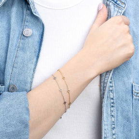 Frau traegt Armband JANNA gold CIAO an Handgelenk, Jeanshemd und weisses Rippshirt
