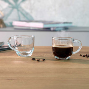 Zwei Espressotassen NAPOLI mit Wasser und Espresso auf Holztisch, Kaffeebohnen daneben