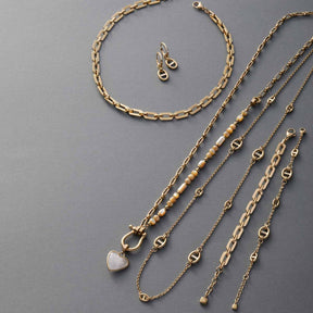 Goldene Halsketten und Ohrringe in verschiedenen Längen und Kettentypen, teilweise mit Glasanhängern