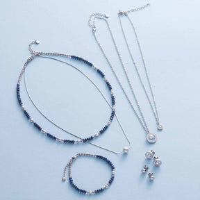 ANJANA Armband und Halsketten aus Edelstahl, Sodalith und Muscheln auf weißem Hintergrund