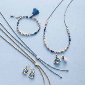 Halskette BABSI, Armband und Ohrringe aus Glasperlen in Blau-, Creme- und Rosatönen auf hellblauem Hintergrund