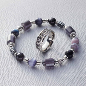Ring ATURA 19 mit lila Glasperlen-Armband auf hellgrauem Untergrund
