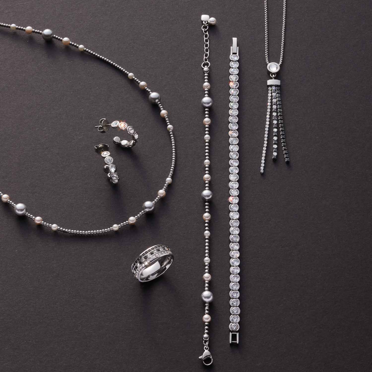 Schmuckset ELSANA mit Halskette, Armband, Ring und Ohrringen in Silber auf grauem Hintergrund