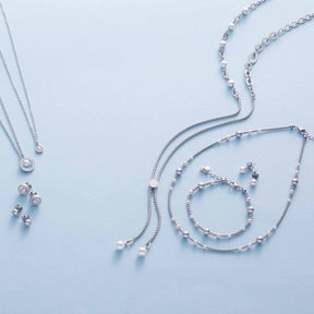Silberne Schmuckkollektion ELSANA mit Armbändern, Ketten und Perlenanhängern auf hellem Hintergrund