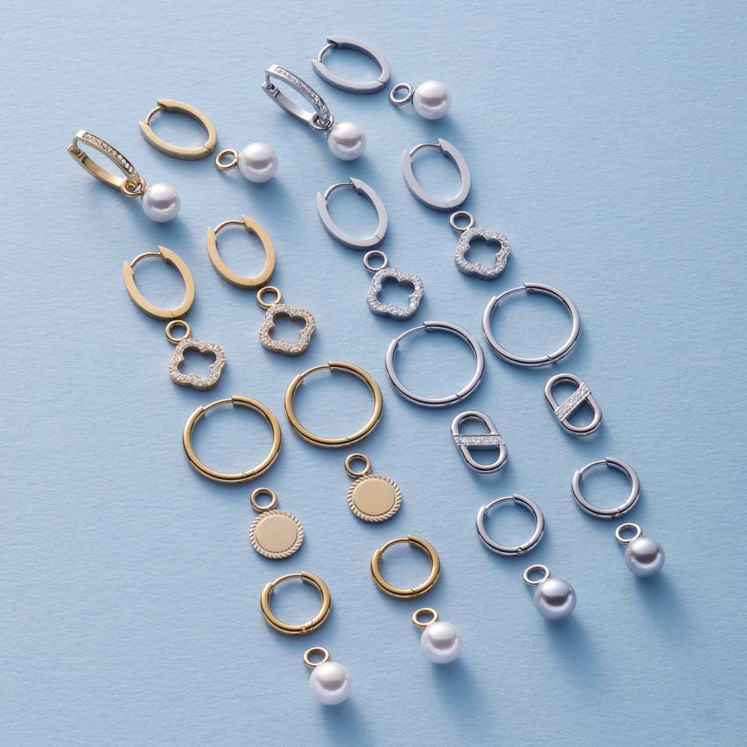 Schmuckanhänger und Ringe in Silber und Gold auf blauem Hintergrund angeordnet