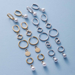Schmuckanhänger und Ringe in Silber und Gold auf blauem Hintergrund angeordnet