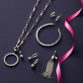 Schmuckkollektion mit Armband CREMONA silber, Kette, Ohrstecker und pinkem Seidenband auf dunklem Hintergrund