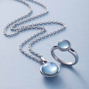 Ring Bea 20 grau blau mit Glaskugel und Silberkette auf hellem Untergrund