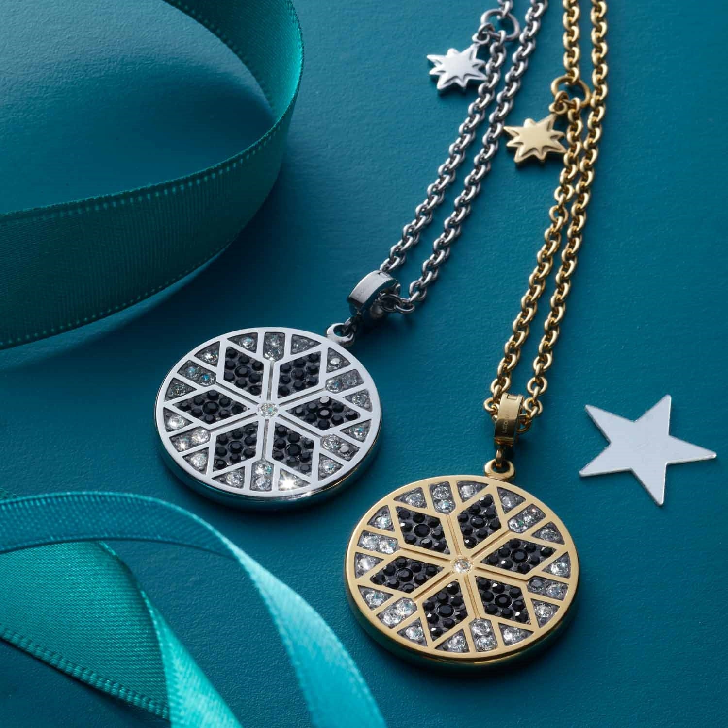 Halskette BIELLA mit rundem Kettenanhänger in Silber und Gold auf türkisblauem Hintergrund mit Schleife und Sternen