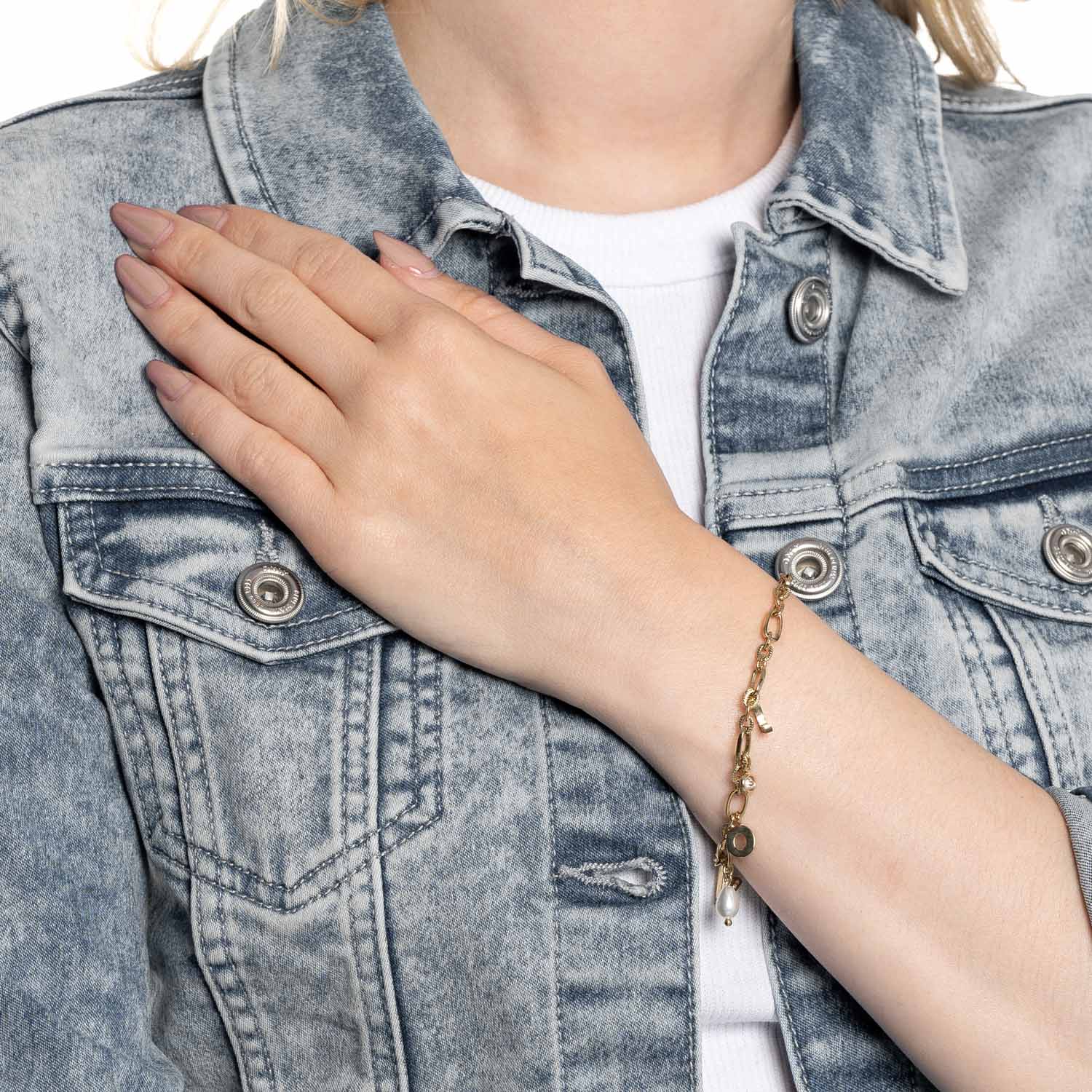 Frau traegt goldenes Armband OTELLA an Handgelenk, Jeanshemd