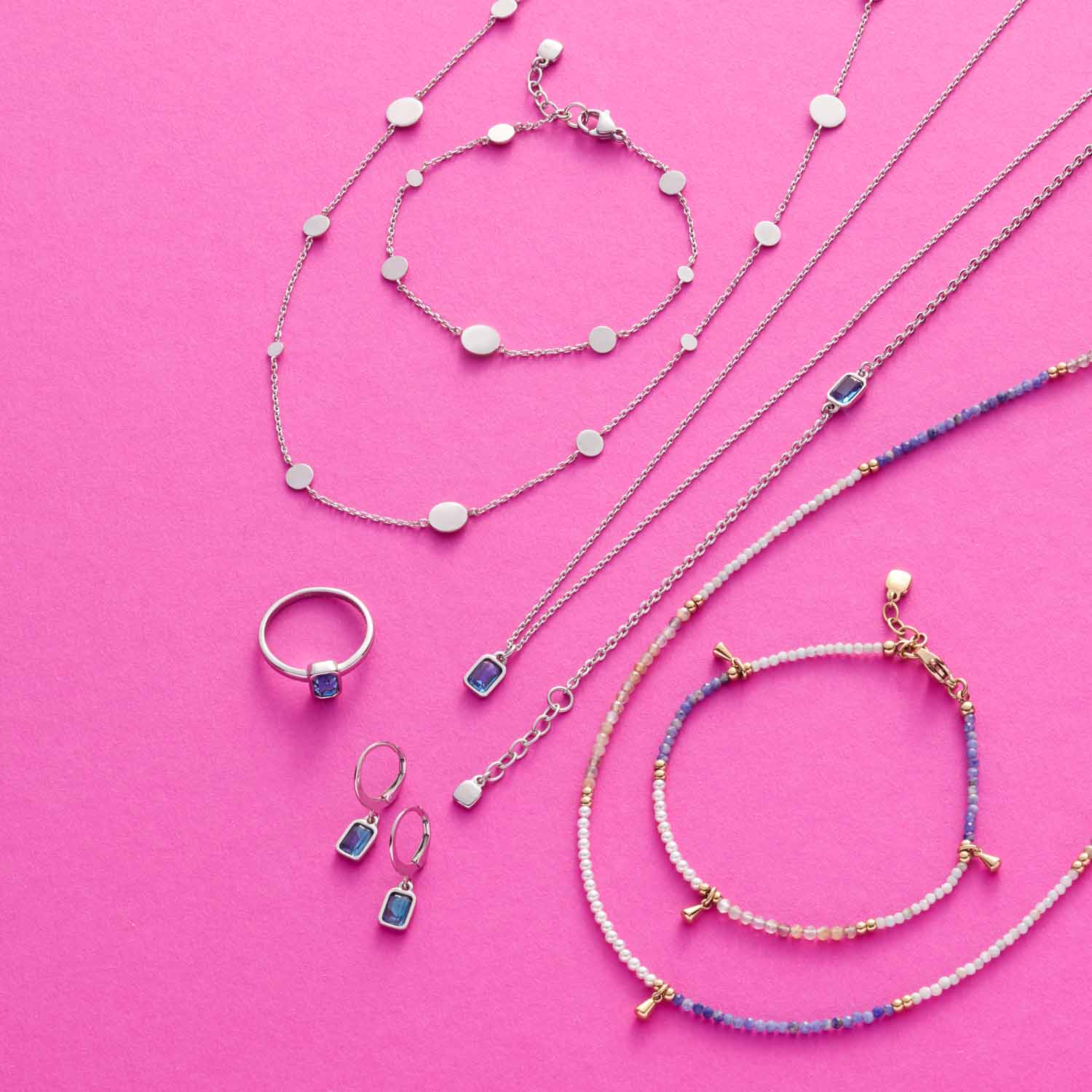 Schmuckkollektion auf rosa Hintergrund: Armbänder, Ketten und Ring mit Perlen, Sodalith und Muscheln