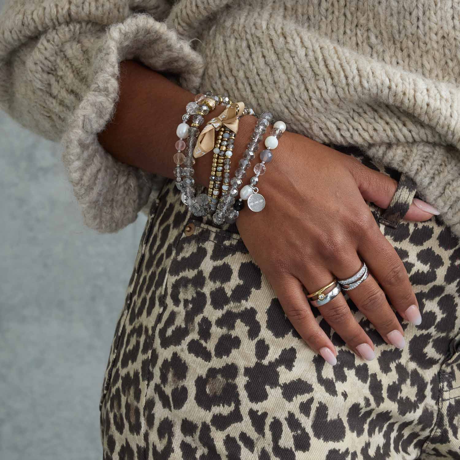 Armband BERNA gold an Frauenhand mit Leoparden-Muster und Pullover