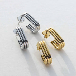 Ohrstecker ELISABETH in Silber und Gold mit gerilltem Oberflächenmuster auf weißem Hintergrund
