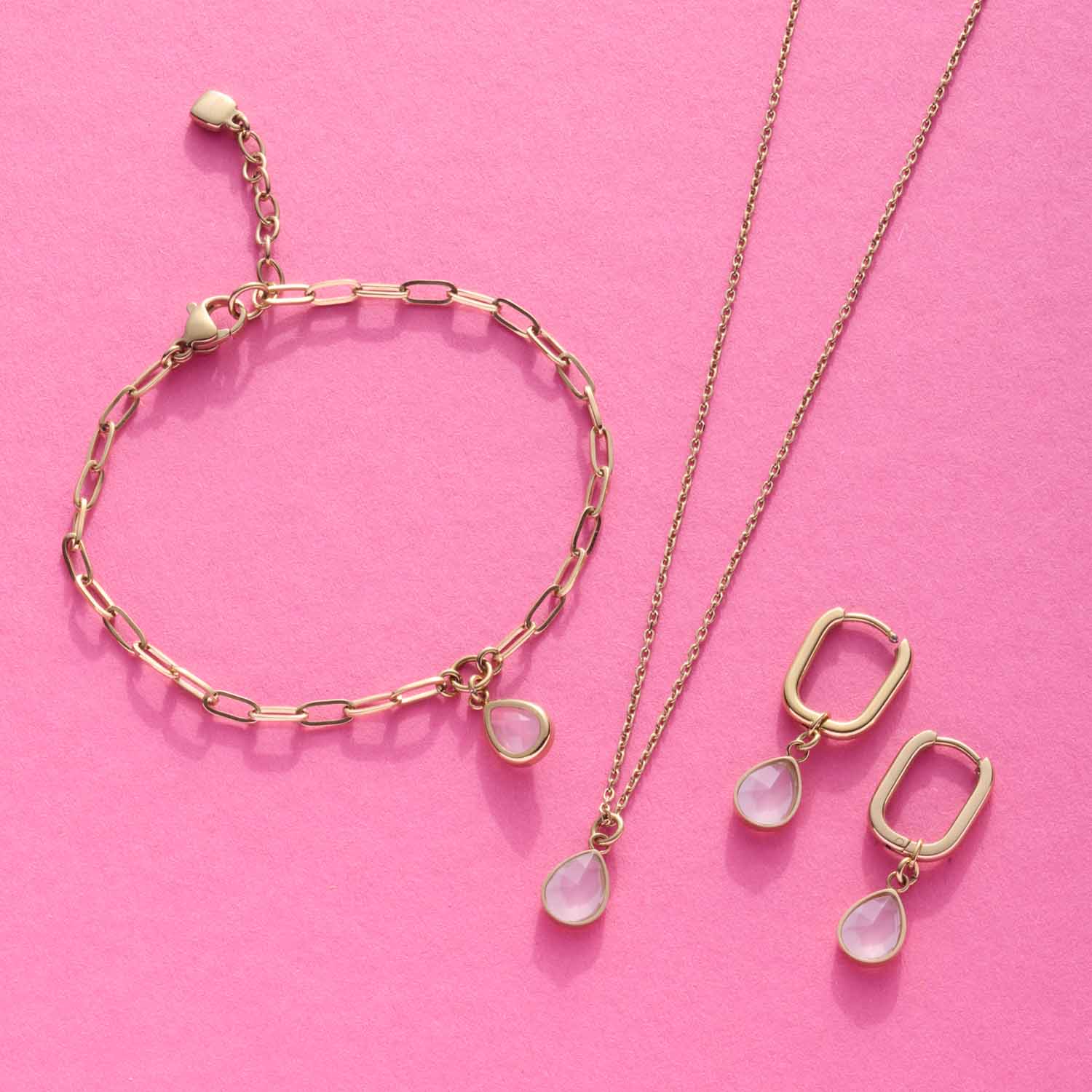 Halskette ROSY mit Glasanhänger, passendes Armband und Ohrringe auf rosa Hintergrund