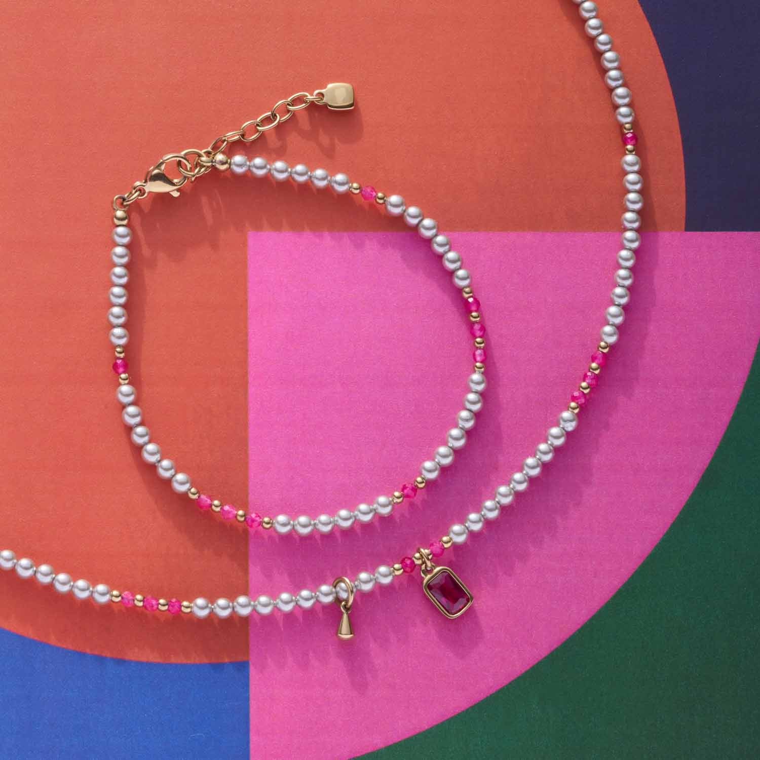 Armband PINKY gold CIAO mit Perlen auf farbigem Hintergrund
