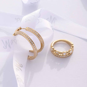 Ring BOBBY 17 gold und Creolen auf weißem Tuch präsentiert
