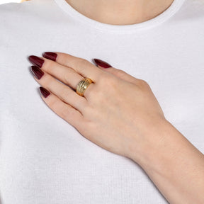 Hand mit goldenem Ring ELISABETH 21, bordeauxrote Nägel, weißes Shirt