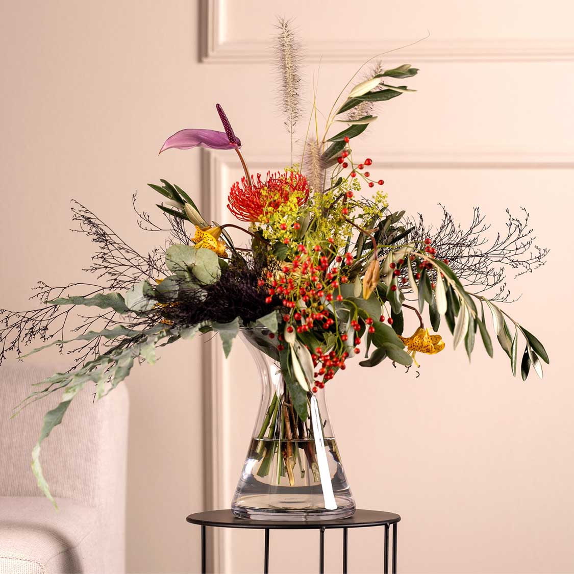 Vase GIA mit buntem Blumenstrauß auf schwarzem Beistelltisch